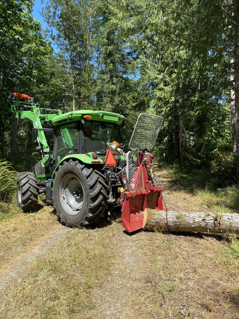 Deutz-Fahr tractor with Tajfun winch yarding a log down a forest trail on the Olympic Peninsula