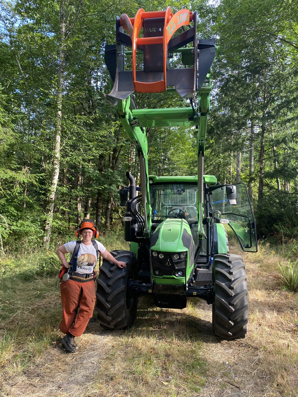 Hannah Jones alongside the Deutz-Fahr 5110 G tractor with front-mounted log grapple raised